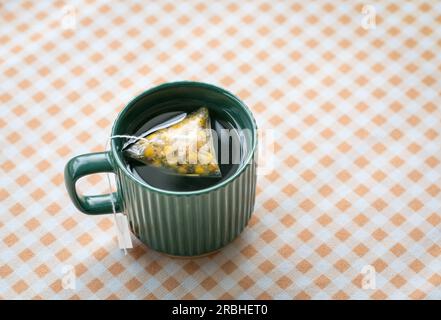 Heißer Tee in einer grünen Tasse. Großer Blickwinkel, Kopierbereich. Stockfoto
