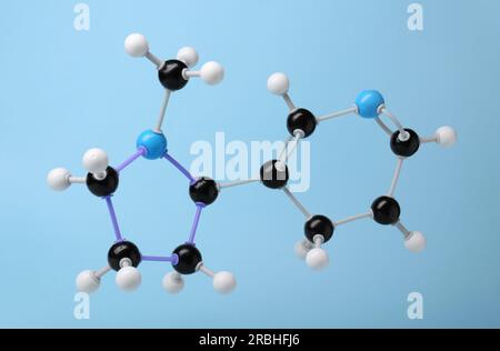 Nikotinmolekül auf hellblauem Hintergrund. Chemisches Modell Stockfoto