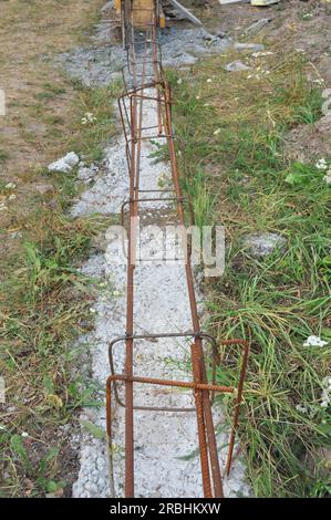 Betongrundlagen für Zäune mit Armierungsstangen. Armierungsstahl für das Fundament von Betonarmierungszäunen. Stockfoto