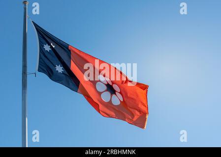 Die Staatsflagge des Northern Territory, 3 offizielle Farben, Schwarz, Weiß und Rot, Ocker und eine Version des Blumenemblems des Territory, Sturt's Desert Rose Stockfoto
