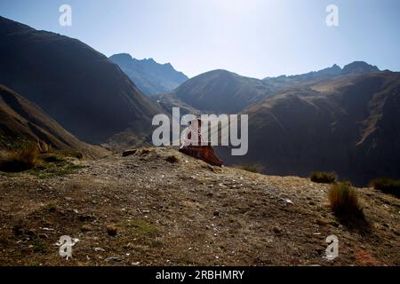 Abra Malaga, Peru; 1. Oktober 2022: Eine Frau aus einem Quechua-Stamm sitzt mit dem heiligen Tal im Hintergrund. Stockfoto