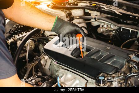 Automatische Prüfung des Ölstands mit dem Ölmessstab eines Pkw-Motors. Autoservice Stockfoto