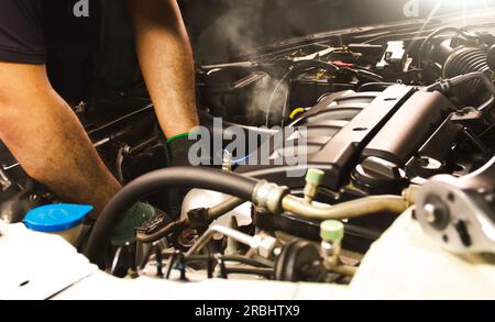 Automechaniker im Auto-Reparaturdienst. Automechaniker, der an einem Motor arbeitet. Stockfoto