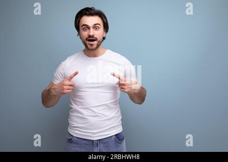Selbstbewusster, starker brünetter Mann in weißem Tanktop mit Muskeln Stockfoto