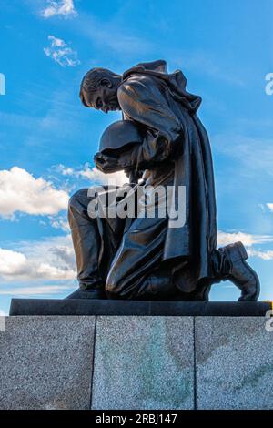 Bronzeskulptur eines knienden Soldaten mit Waffe und Helm am Sowjetischen Kriegsdenkmal im Treptow-Park, Berlin Stockfoto