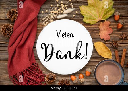 Herbstdeko, flach gelegen mit bunten Ahornblättern, gemütliche Atmosphäre und Label mit deutschem Text Vielen Dank, was auf Englisch viel Dank bedeutet Stockfoto