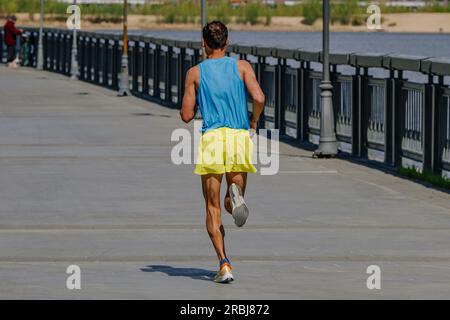 Rückansicht Sportler Runner Running Marathon Race in River Embankment, Sommersportveranstaltung Stockfoto
