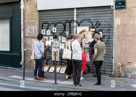 Die Leute besuchen und diskutieren die improvisierte, temporäre Kunstgalerie auf der Straße in der Rue Vielle du Temple, 3 Arr. Paris Stockfoto