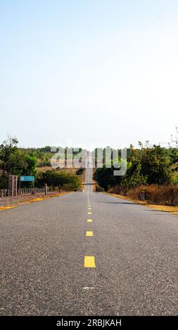 Foto zur Bestätigung des Ziels und des richtigen Weges. Nie Aufhören, Motivierend Zu Sein. Wunderschöne Aussicht auf die leere Asphaltstraße mit gelber Linie in der Berglandschaft Stockfoto