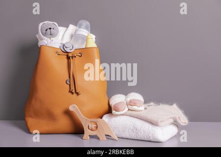 Mutters Tasche mit Babysachen auf grauer Kommode Stockfoto