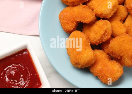 Leckeres Ketchup und Chicken Nuggets auf dem Tisch, flach liegend Stockfoto