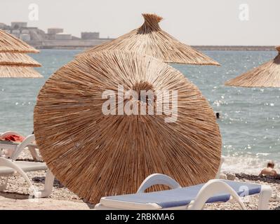 Ein heruntergefallener Bambusschirm am Strand. Leere Ferienplätze Stockfoto