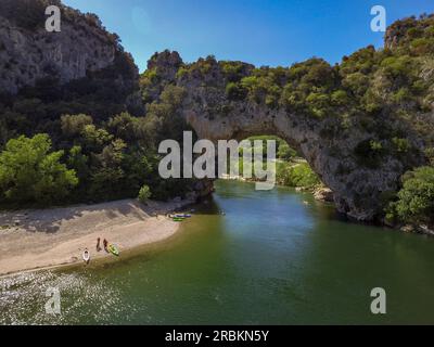 Aus der Vogelperspektive vom Felsbogen Pont Arch in den Gorges de L'ardeche mit Kanus und Sandbank des Flusses Ardeche, Labastide-de-Virac, Ardèche, Auvergne-Rhône-Alpes, Frankreich, Europa Stockfoto