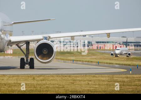 Heiße Luft hinter dem Triebwerk des Flugzeugs am Flughafen. Das Flugzeug fährt während des sonnigen Sommertags zur Startbahn. Stockfoto