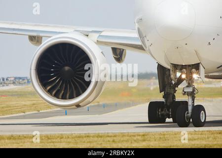 Heiße Luft hinter dem Triebwerk des Flugzeugs am Flughafen. Das Flugzeug fährt während des sonnigen Sommertags zur Startbahn. Stockfoto