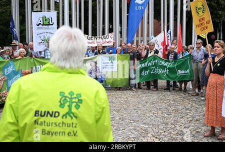 München, Deutschland. 10. Juli 2023. Richard Mergner (Front l), Vorsitzender der Deutschen Naturschutzunion in Bayern, spricht vor dem Europäischen Patentamt bei einer Kundgebung gegen die neue Gentechnik (NGT) in der Landwirtschaft. Veranstalter ist die Allianz für gentechnikfreie Natur und Landwirtschaft in Bayern, einschließlich Bund Naturschutz, Greenpeace, Landesbund für Vogel- und Naturschutz und die Verbraucherzentrale. Kredit: Felix Hörhager/dpa/Alamy Live News Stockfoto