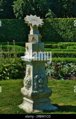 Eine Sandsteinsonne aus dem 18. Jahrhundert in einem formellen Garten. Menkemaborg, Uithuizen, Niederlande Stockfoto