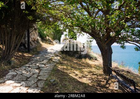 Bulgarien. Steinpfad in der Nähe von Klippen und mittelalterlichen Festungsruinen in Cape Kaliakra an einem sonnigen Sommertag mit Meer und blauem Himmel im Hintergrund. Stockfoto