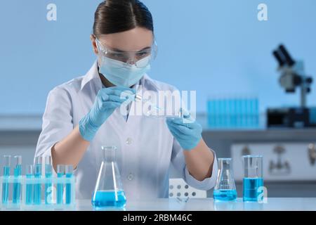 Wissenschaftler tropft Flüssigkeit aus der Pipette in die Petrischale im Labor Stockfoto