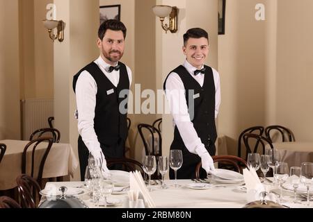 Männer decken den Tisch im Restaurant. Professionelle Butler-Kurse Stockfoto