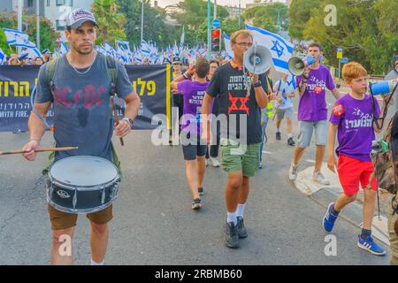 Haifa, Israel - 08. Juli 2023: Menschen marschieren mit Flaggen und verschiedenen Zeichen. Woche 27 des Protests gegen die Regierung in Haifa, Israel Stockfoto