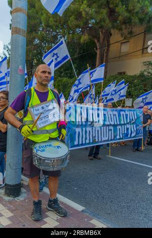 Haifa, Israel - 08. Juli 2023: Menschen marschieren mit Flaggen und verschiedenen Zeichen. Woche 27 des Protests gegen die Regierung in Haifa, Israel Stockfoto