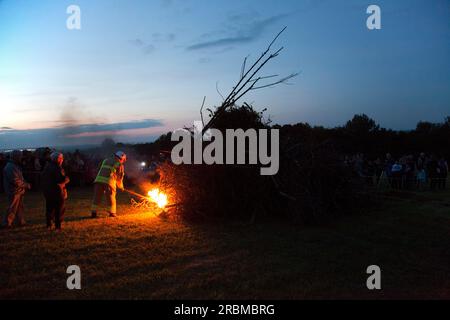 Eine riesige Menschenmenge beobachtet einen Feuerwehrmann, der ein Leuchtfeuer zur Feier des Diamantenjubiläums Ihrer Majestät Königin Elisabeth II. In Faringdon, England, im April 2012 zündet Stockfoto