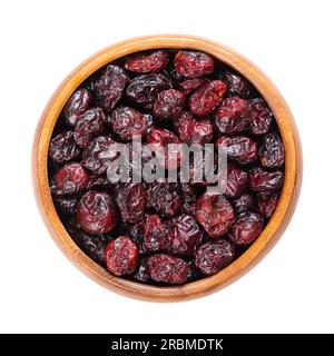 Getrocknete große Preiselbeeren in einer Holzschüssel. Reife Früchte von Vaccinium macrocarpon, auch bekannt als amerikanische Cranberry oder Bärenbeere. Rote Beeren. Stockfoto