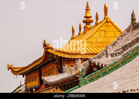 Vergoldetes Dach mit Figuren und Ornamenten auf einem atemberaubenden Gebäude im Kloster Kumbum, Xining, China Stockfoto