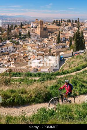 Nette, aktive Seniorin, die mit ihrem E-Mountainbike in Granada unter dem Weltkulturerbe Alhambra, Granada, Andalusien, Spanien radelt Stockfoto