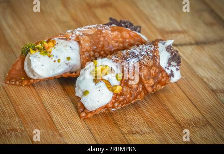 Ein italienischer Cannoli gefüllt mit Ricotta Creme auf Holzbrett. Stockfoto