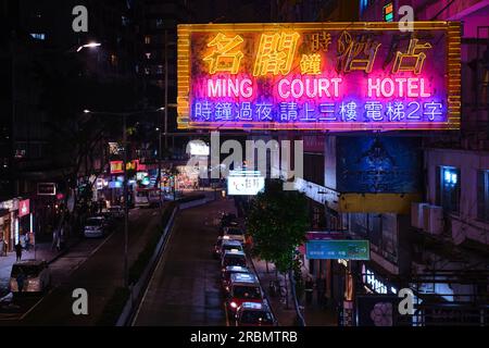Hongkong, China - April 28 2023: Farbenfrohes Neonlicht Schild mit Hotel und roter Taxilinie bei Nacht auf der Lockhart Road Stockfoto