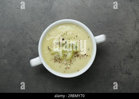 Schüssel mit köstlicher Selleriesuppe auf grauem Tisch, Draufsicht Stockfoto