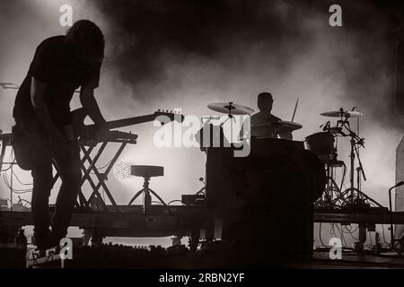 Fesselndes Schwarz-Weiß-Konzert mit dynamischer Band, Bühne auf Rockfestival, Silhouetten für Musikinstrumente Stockfoto