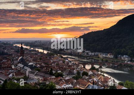 Die Altstadt von Heidelberg mit dem Fluss Neckar und der Alten Brücke bei Sonnenuntergang. Das Bild stammt aus der Öffentlichkeit. Deutschland. Stockfoto