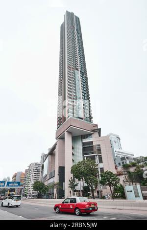 Hongkong, China - April 28 2023: Das Victoria Towers Wohnhaus mit Wohnhochhäusern neben Xi Qu in Kowloon mit einem klassischen roten Taxi Stockfoto