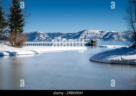 Wo der Truckee River im Winter auf Lake Tahoe trifft, mit wolkenlosem blauem Himmel und Wasser und einem Pier Stockfoto