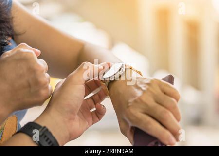 Nahaufnahme eines Mannes mit dem Daumenfinger, der der Frau beibringt, wie die Anwendung auf einer Smartwatch verwendet wird. Ein Mann bringt einer Frau vor, wie man eine Smartwatch benutzt Stockfoto