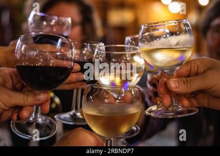 Freunde stoßen mit Weingläsern im Freiluftrestaurant La Guinguette neben dem Canal du Midi, Argens-Minervois, Aude, Frankreich, Europa an Stockfoto