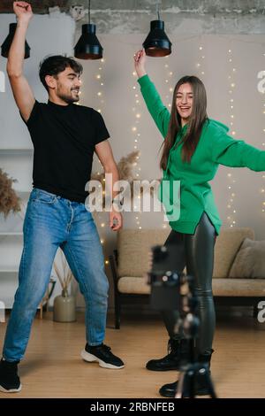 Fröhliche Asiatin mit erhobenen Armen im Zimmer Stockfoto