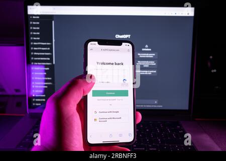 Azoren, Portugal - 21.01.2023: Smartphone-Bildschirm mit ChatGPT-Login-Webseite mit Laptop im Hintergrund. ChatGPT von OpenAI entwickelt Stockfoto
