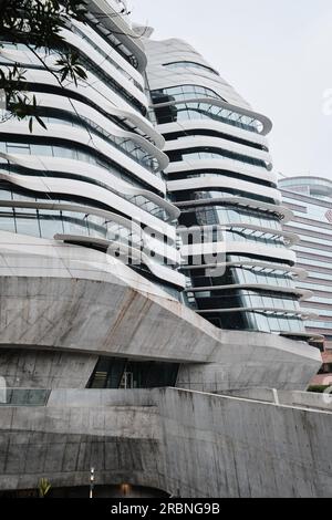 Hongkong, China - April 28 2023: Der von der Architektin Zaha Hadid entworfene Jockey Club Innovation Tower. Sie gehören zur Polytechnic University School of Design Stockfoto