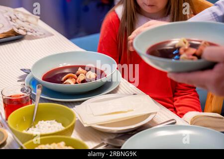 Borschtsch, Borsch mit Ravioli, Suppe aus roten Rüben, traditionelles polnisches Weihnachtsessen, Gericht auf dem Familientisch serviert, Detail, Nahaufnahme. Heiligabend feiern Stockfoto