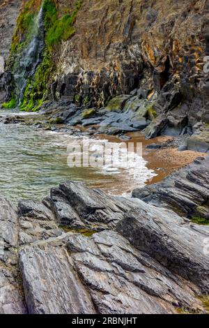 Die Klippen und der Wasserfall in Tresaith in Ceredigion West Wales UK, wo der Afon Saith oder Saith River ins Meer stürzt. Stockfoto