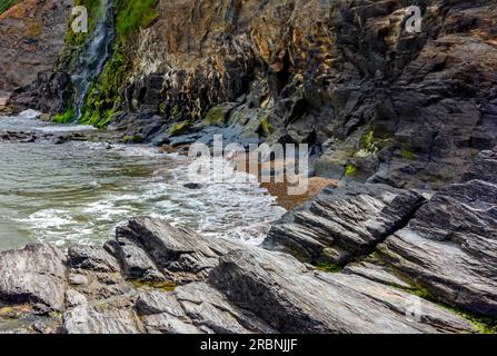 Die Klippen und der Wasserfall in Tresaith in Ceredigion West Wales UK, wo der Afon Saith oder Saith River ins Meer stürzt. Stockfoto