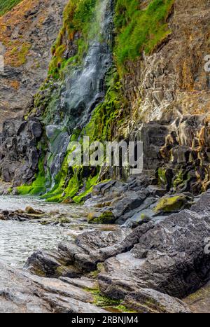 Die Klippen und der Wasserfall in Tresaith in Ceredigion West Wales UK, wo der Afon Saith oder Saith River ins Meer stürzt. Stockfoto