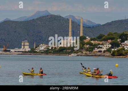 Eine Gruppe von Kanufahrern, die entlang der Küste von Alcanada, Alcudia, segeln. Mallorca, Balearen, Spanien. Stockfoto