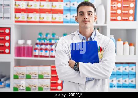 Junger hispanischer Apotheker mit Klemmbrett in der Apotheke Stockfoto