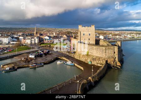 Mittelalterlichen normannischen Burg, Hafen mit Bootsrampe und Wellenbrecher in Carrickfergus bei Belfast, Nordirland, Großbritannien. Luftbild bei Sonnenuntergang in WIN Stockfoto