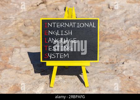 IELTS-Symbol. Konzeptbegriffe IELTS internationales englischsprachiges Testsystem auf schwarzer Tafel. Wunderschöner Steinhintergrund. Business IELTS Praktikant Stockfoto